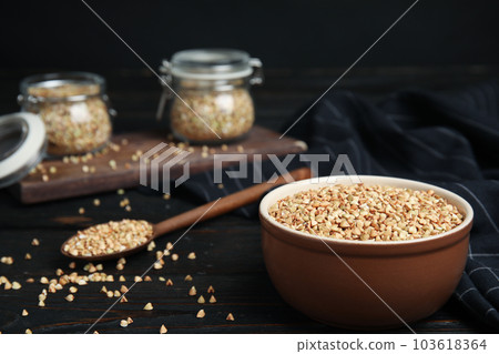 Organic green buckwheat on black wooden table Organic green buckwheat on black wooden table 103618364