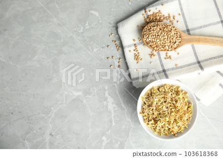 Bowl of sprouted green buckwheat and spoon with grains on light grey table, flat lay. Space for text Bowl of sprouted green buckwheat and spoon with grains on light grey table, flat lay. Space for text 103618368