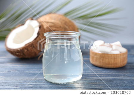 Coconut oil on blue wooden table, closeup view 103618703