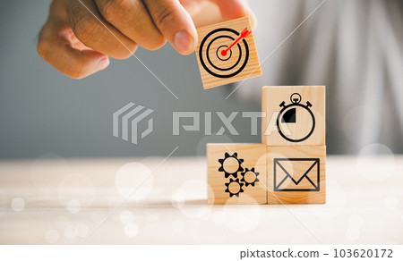 Wood block stacking guided by a businessman's hand, symbolizing a strategic business plan and Action plan. It represents the concept of business management and development. Wood block stacking guided by a businessman's hand, symbolizing a strategic business plan and Action plan. It represents the concept of business management and development. 103620172