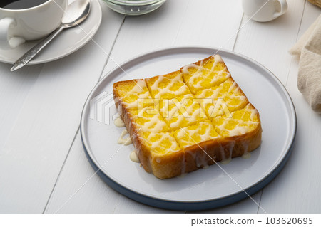Air fryer grilled butter toast,golden brown crispy bread topped with sugar and sweetened condensed milk on white plate 103620695