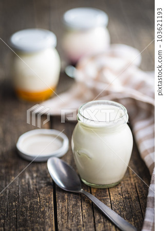 White yogurt in jar on wooden table. 103621193