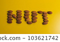 Inscription nut from almond grains on a yellow background 103621742