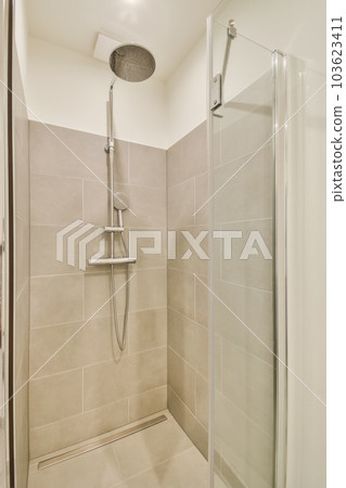 a bathroom with a shower and toilet roll - in system on the wall next to it is a white tiled floor a bathroom with a shower and toilet roll - in system on the wall next to it is a white tiled floor 103623411