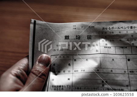 A man's hand crumpling a divorce paper A man's hand crumpling a divorce paper 103623558