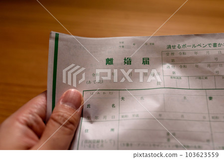 A man's hand crumpling a divorce paper A man's hand crumpling a divorce paper 103623559