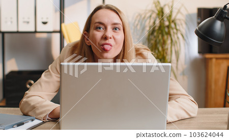 Office businesswoman hiding behind laptop computer make funny silly face fooling around, disrespect 103624044