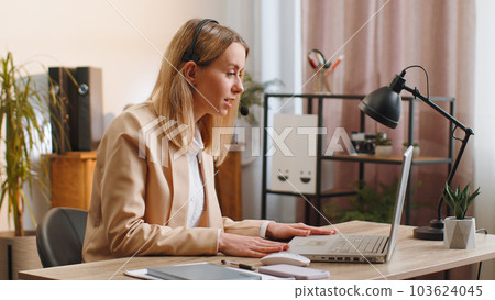 Businesswoman working on laptop wearing headset call center support service operator office helpline 103624045