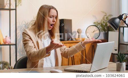 Business woman works on laptop loses becoming surprised sudden lottery results bad news fortune loss 103624061