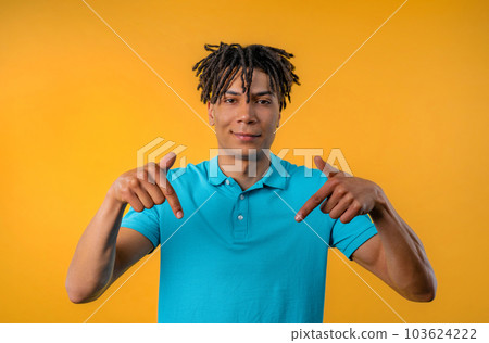 African american man pointing down advertising area. Guy asking click subscribe 103624222