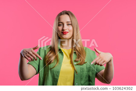 Pretty woman pointing down to advertising area. Pink background. Click subscribe Pretty woman pointing down to advertising area. Pink background. Click subscribe 103624302