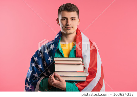 American student man student with stack of books pink background. Education USA 103624332