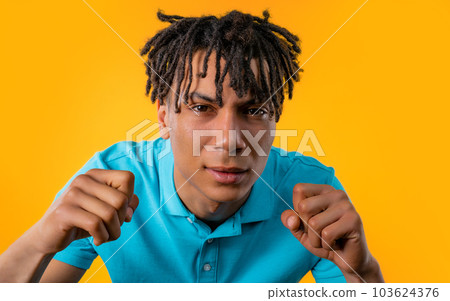 African man rubs eyes, peers more closely at camera on yellow, unbelievable African man rubs eyes, peers more closely at camera on yellow, unbelievable 103624376