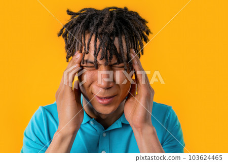 Man with headache, studio portrait.Guy putting hands on head, isolated on yellow Man with headache, studio portrait.Guy putting hands on head, isolated on yellow 103624465