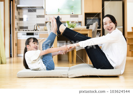 母親和女兒在家裡的客廳裡伸展 103624544