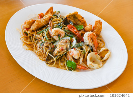 noodles plate with spaghetti pasta stir fried with vegetables herb spicy tasty appetizing asian noodles mix seafood stir fried shrimp squid shellfish fish with basil and chilli pepper 103624641