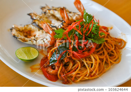 noodles plate with spaghetti pasta stir fried with vegetables herb spicy tasty appetizing asian noodles mix seafood stir fried shrimp squid shellfish fish with basil and chilli pepper 103624644