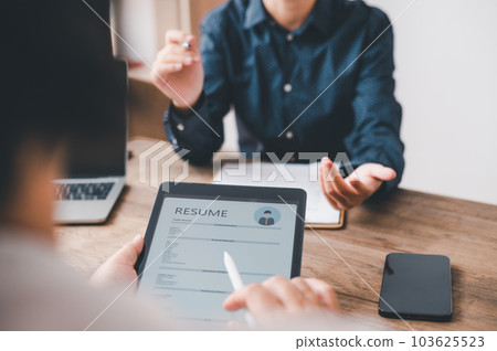 HR managers are interviewing job applicants who fill out their resume on the job application form in order to consider accepting a job as a company HR managers are interviewing job applicants who fill out their resume on the job application form in order to consider accepting a job as a company 103625523
