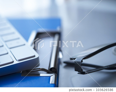 桌上的活頁夾、鍵盤和眼鏡 桌上的活頁夾、鍵盤和眼鏡 103626586