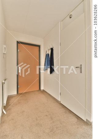 an empty room with some clothes hanging on the wall and a door in the corner to the left is open an empty room with some clothes hanging on the wall and a door in the corner to the left is open 103628266