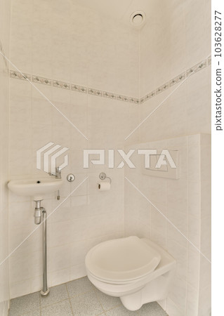 a white toilet in a bathroom with tile flooring and wall - to - wall tiles on the walls behind it a white toilet in a bathroom with tile flooring and wall - to - wall tiles on the walls behind it 103628277