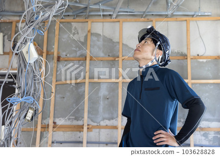 A worker man checking the ceiling at the work site 103628828