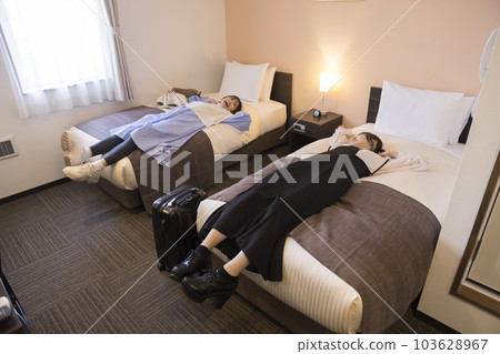 A young woman lying on the bed in her guest room after checking in. Travel, business trip image A young woman lying on the bed in her guest room after checking in. Travel, business trip image 103628967