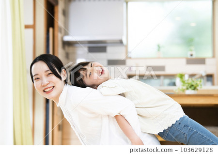 母親和女兒在家裡的客廳裡伸展 103629128