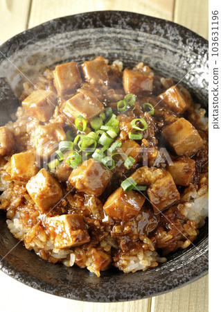 A bird's-eye view of a hot mapo tofu bowl full of small onions and tofu 103631196