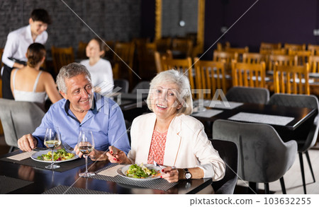 Elderly couple of spouses, husband and wife, communicate in restaurant during dinner. Elderly couple of spouses, husband and wife, communicate in restaurant during dinner. 103632255