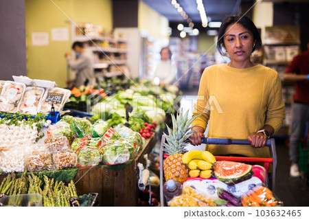 Woman shopping at store, walking among shelves 103632465