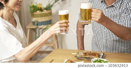 一對成熟夫婦在家裡用啤酒敬酒的手的特寫 103632913