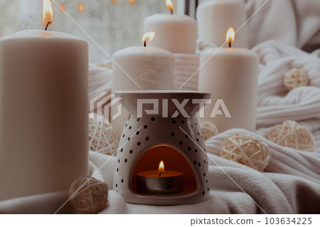 Aroma lamp with essential oil, aromatherapy at home, burning candle, dropping essential oil. Concept of home relaxation and anti stress. Natural Spa treatment Home fragnance at cozy home on the 103634225