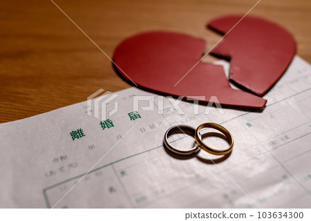 Divorce papers and wedding rings and a heart split in two Heartbreak 103634300