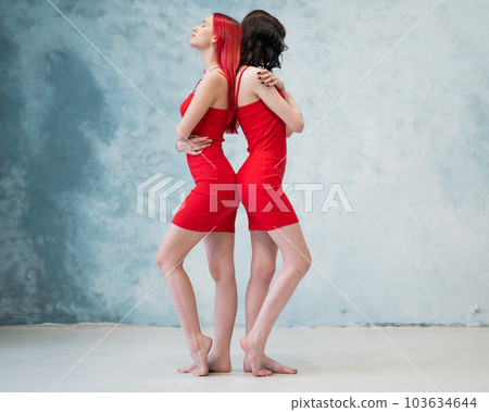 red dress lesbian Full-length Portrait of Two Tenderly Embracing Women Dressed in Identical Red  Dresses. Lesbian Intimacy. Stock Image