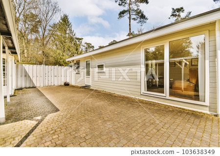 a house that is in the process of being remodeled and renovated with new siding, brick paversing and white trim 103638349