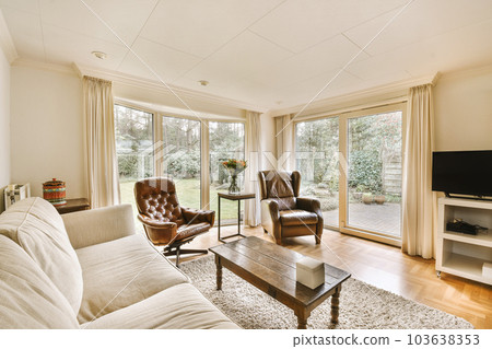 a living room with two couches, a coffee table and a flat screen tv on the wall behind it a living room with two couches, a coffee table and a flat screen tv on the wall behind it 103638353
