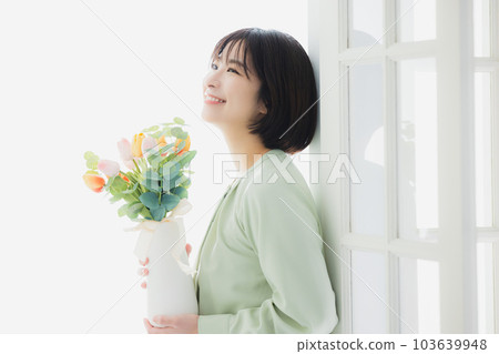 A woman holding a vase of tulips A woman holding a vase of tulips 103639948