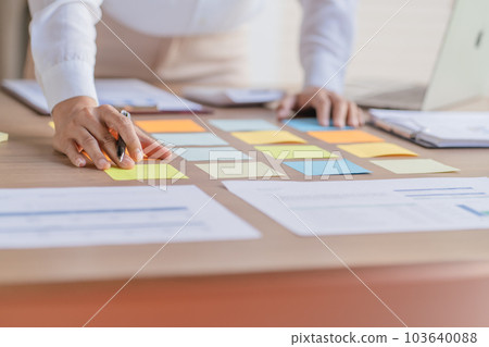 Business People working on sticky notes creative writing down ideas on post it notes professional investor start up project business. 103640088