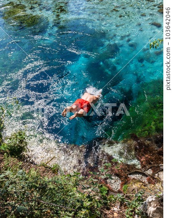 Man jumping to the Blue eye spring near Sarande, Albania 103642046