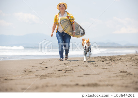 一個帶著衝浪板的女人和一隻穿著皮疹衛衣的狗 一個帶著衝浪板的女人和一隻穿著皮疹衛衣的狗 103644201