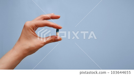 capsule in hand on a blue background, medication, medical workers day, medical care, banner for the hospital capsule in hand on a blue background, medication, medical workers day, medical care, banner for the hospital 103644655