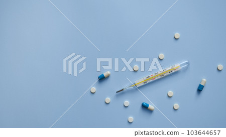 thermometer, capsules and tablets on a blue background, medication, medical workers day, medical care, banner for hospital, template for text thermometer, capsules and tablets on a blue background, medication, medical workers day, medical care, banner for hospital, template for text 103644657