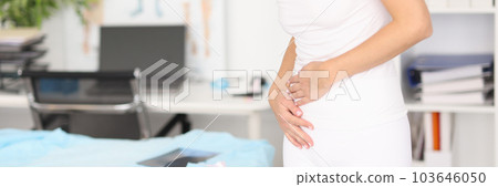 Woman with severe abdominal pain in clinic Woman with severe abdominal pain in clinic 103646050