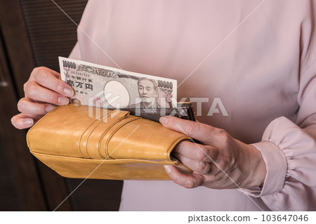 [Housewife takes out 10,000 yen bill from long wallet] 103647046