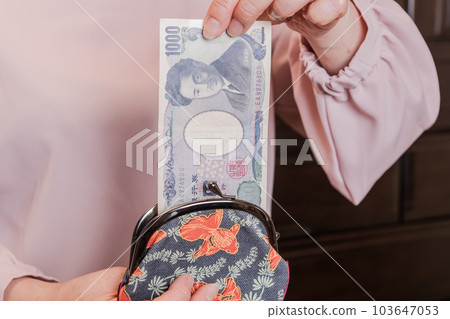 [A housewife takes out a 1000 yen bill from her clasp] 103647053