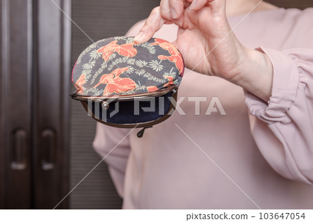 [A housewife turning over an empty clasp] 103647054