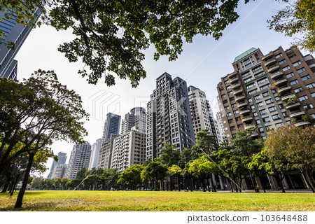 Low-angle view of green park space and modern buildings on both sides in downtown Taichung, Taiwan. here is near the National Taichung Theater. 103648488
