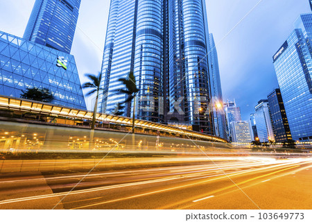 Office skyscraper buildings and busy traffic on highway roads with blurred car light trails in Central, hong kong. Office skyscraper buildings and busy traffic on highway roads with blurred car light trails in Central, hong kong. 103649773
