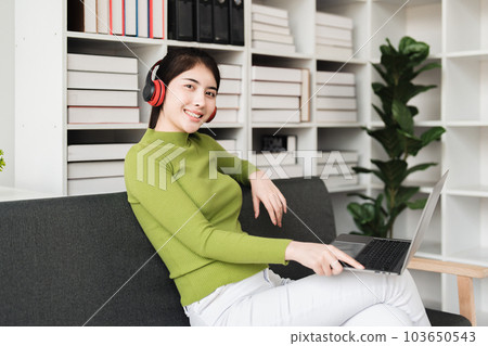 Young relaxed smiling pretty woman relaxing sitting on sofa at home. Female feeling joy enjoying with music on cozy couch Young relaxed smiling pretty woman relaxing sitting on sofa at home. Female feeling joy enjoying with music on cozy couch 103650543